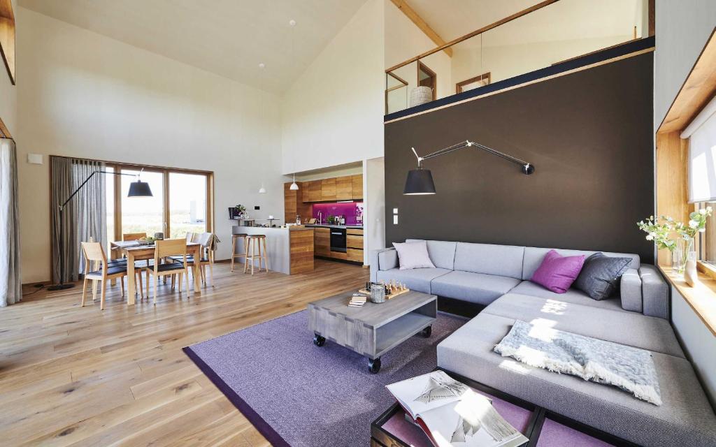 uma sala de estar com um sofá e uma mesa em Gud Jard Chalet Nr 07 - Design-Ferienhaus mit exklusiver Ausstattung em Pellworm
