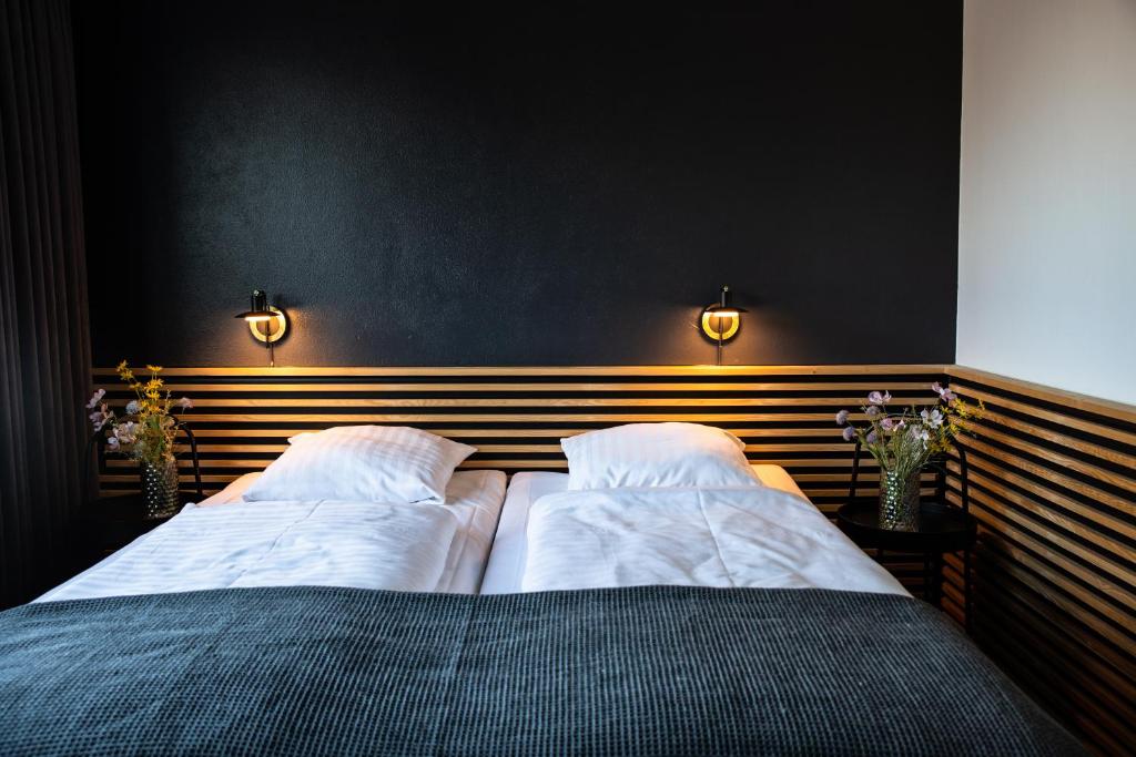 a bedroom with two beds and two lights on the wall at Hotel-B in Birkerød