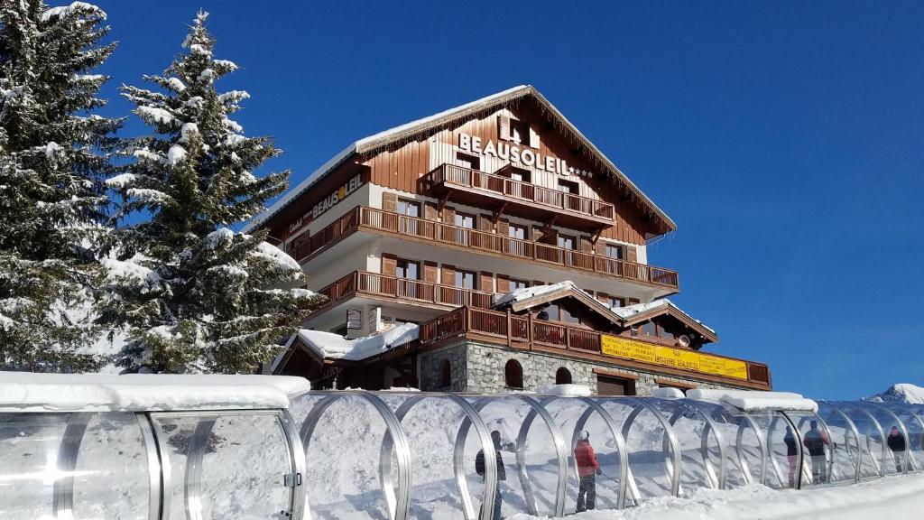 サン・ソルラン・ダルヴにあるChalet Beausoleil 4 étoiles - jacuzzi - au pied des pistes - domaine les sybellesの雪の中の建物