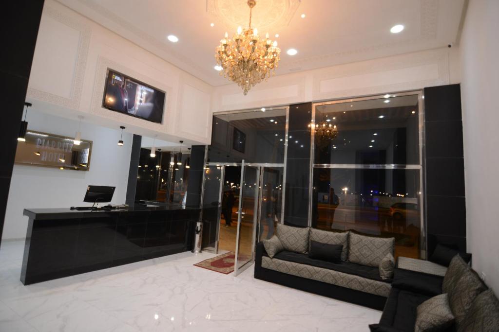 a lobby with a couch and a chandelier at Hotel Biarritz in Tangier