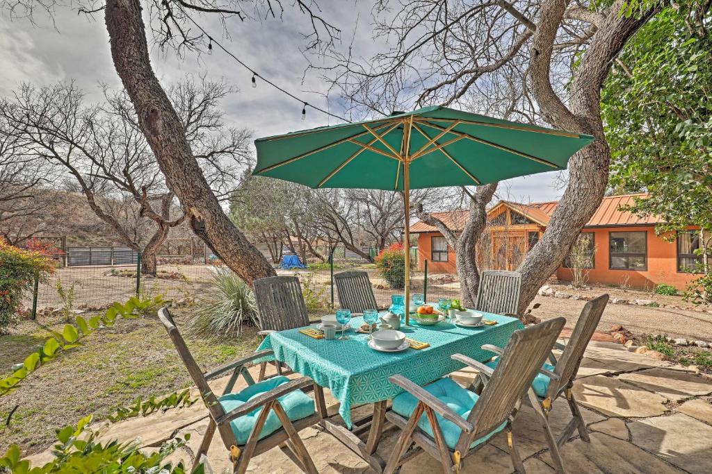 a table and chairs with a green umbrella at Casa Paloma 1 - Artsy Studio with Hot Tub Access! in Patagonia