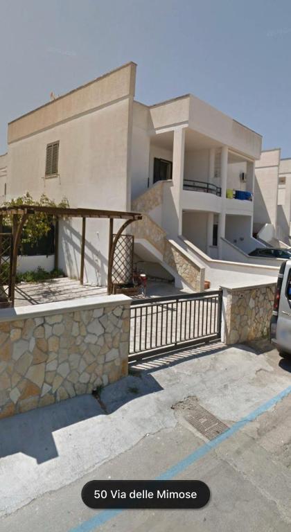 a house with a stone retaining wall and a driveway at Villeta Laura in Baia verde in Il Monte