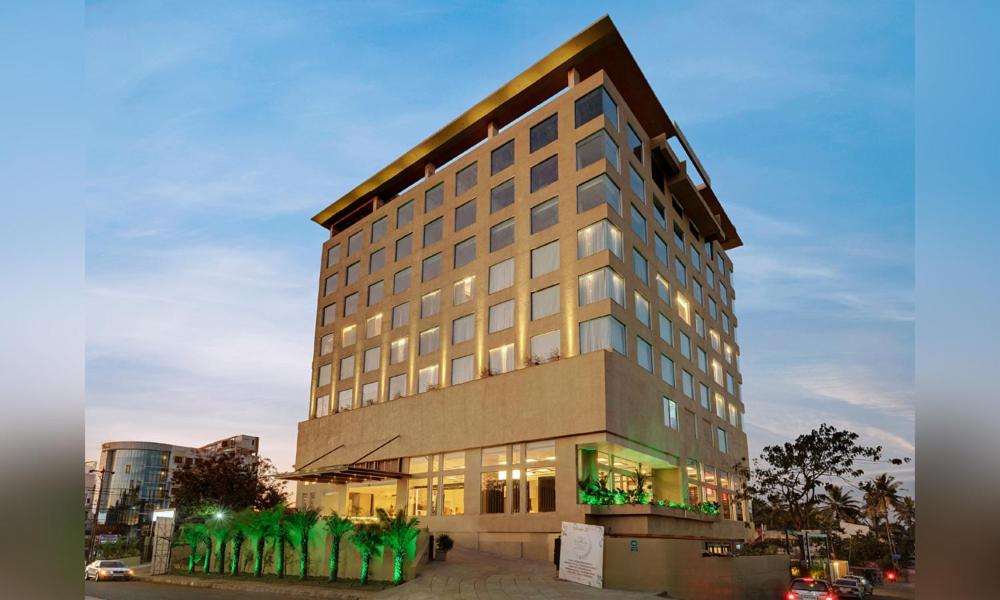 a tall building with a lot of windows at Veeksar The Fern An Ecotel Hotel Kolhapur in Kolhapur
