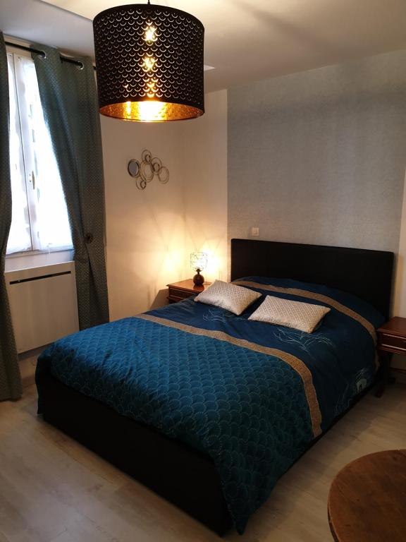 a bedroom with a bed with a blue blanket at Le Jacobin in Troyes