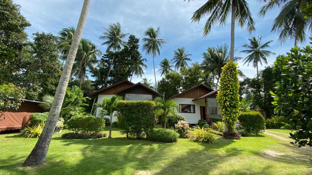 uma casa no meio de um quintal com palmeiras em Sean Sabai Home e Ristobar em Praia de Taling Ngam