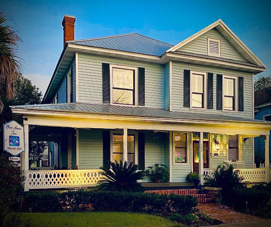 a white house with a porch and a house at Blue Heron Inn in Fernandina Beach