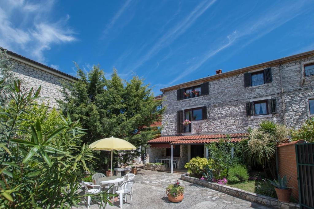 an external view of a building with an umbrella at Apartmani Mirjana Umag in Umag