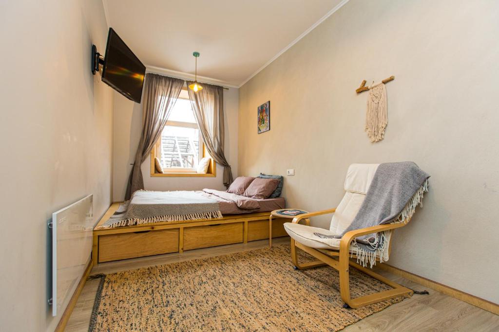 リヴィウにあるModern apartment on Lemkivskaのベッド1台、椅子、窓が備わる客室です。