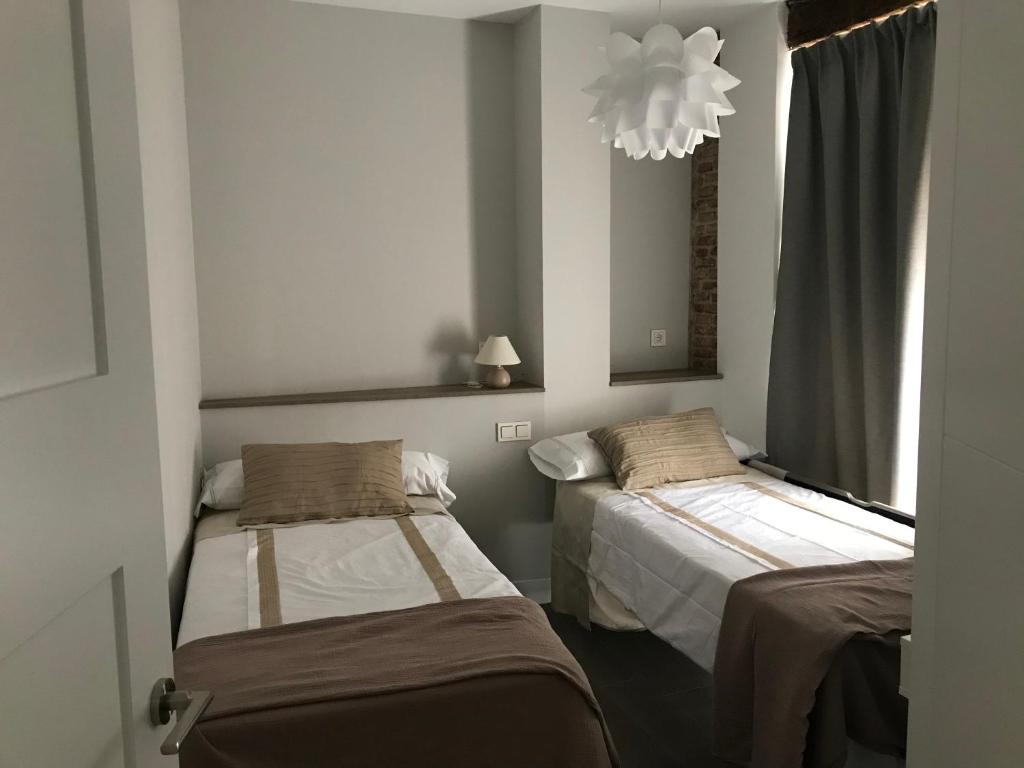 A bed or beds in a room at Apartamentos DUKE