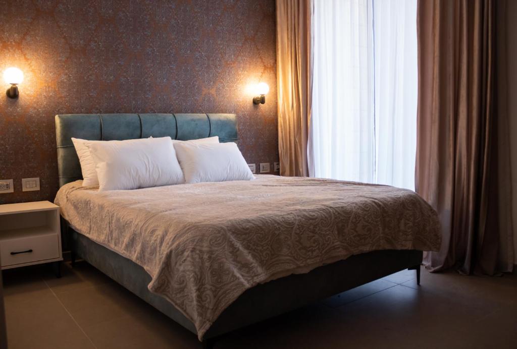 拿撒勒的住宿－Amwaj Apartments，一间卧室设有一张大床和一个窗户。