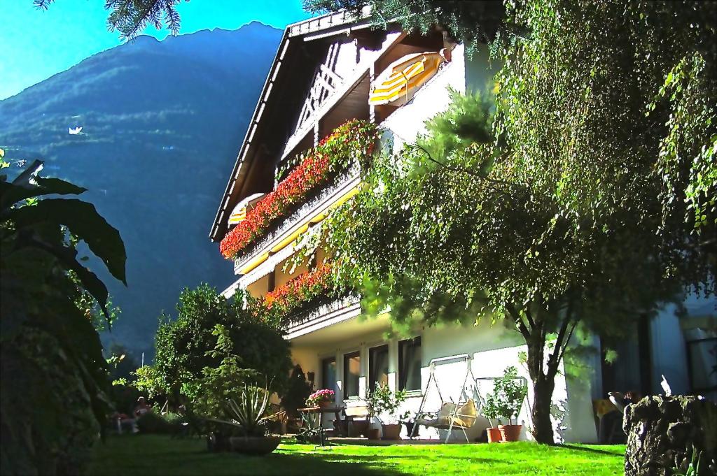 a building with flower boxes and a mountain in the background at Guntraun in Parcines