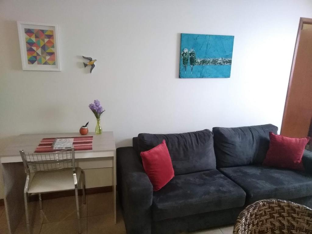 a living room with a blue couch and a table at Ipê Rosa Apartamento in Brasilia