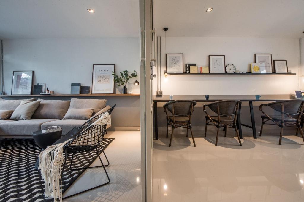 uma sala de estar com um sofá e uma mesa em Aridom Designer Loft House em Bangkok