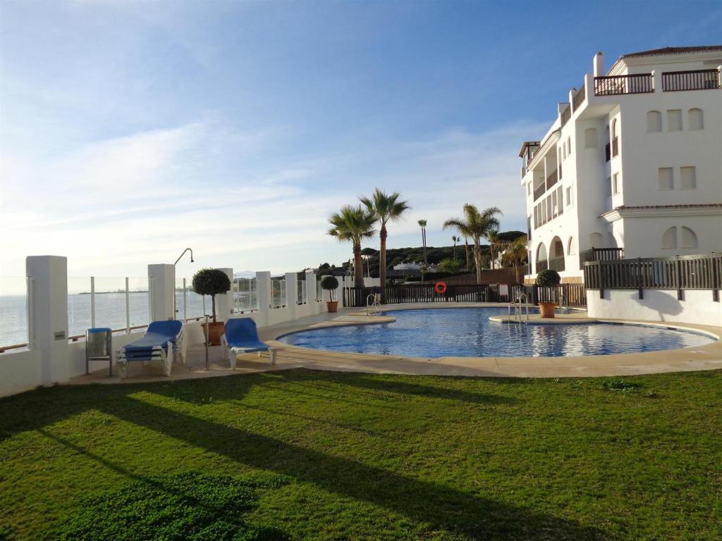 a building with a swimming pool next to the ocean at Seaview Puerta del Mar first line beach in Sitio de Calahonda