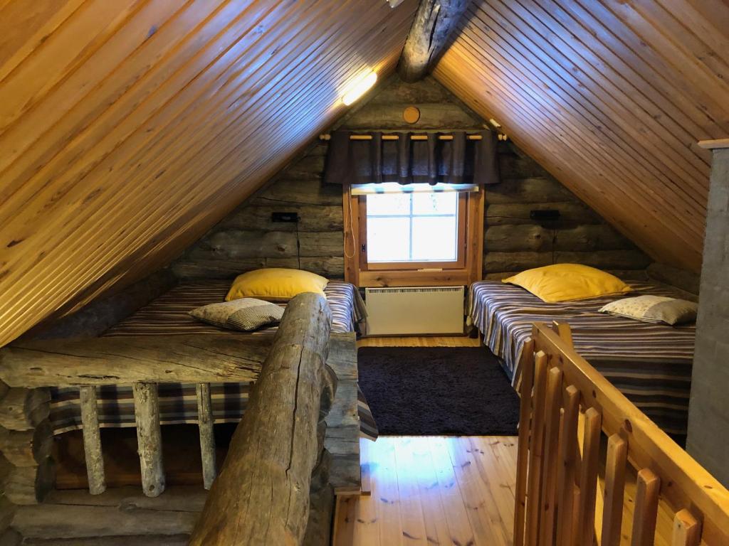 Habitación con 2 camas en una cabaña de madera en Villa Kelotupa, en Hossa