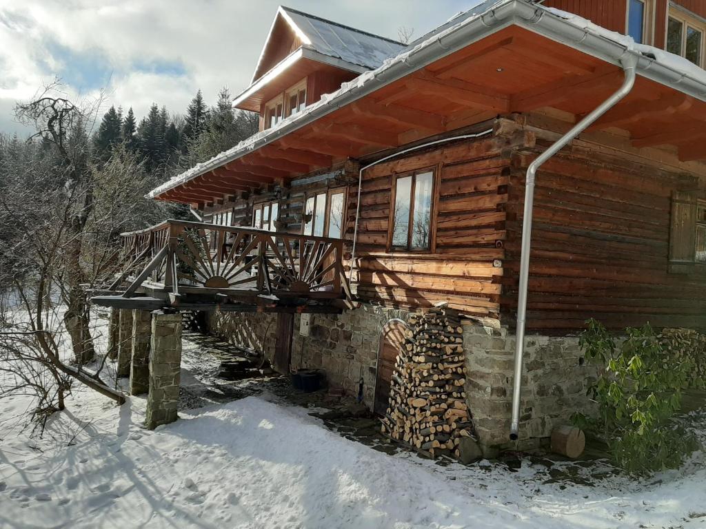 une cabane en rondins avec une terrasse dans la neige dans l'établissement Chałupa z widokiem w górach, à Zawoja