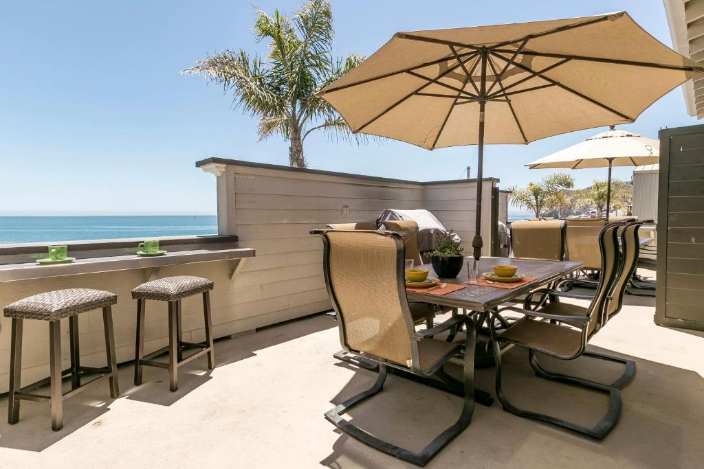 einen Tisch und Stühle mit Sonnenschirm auf einer Terrasse in der Unterkunft 356 Front Street in Avila Beach