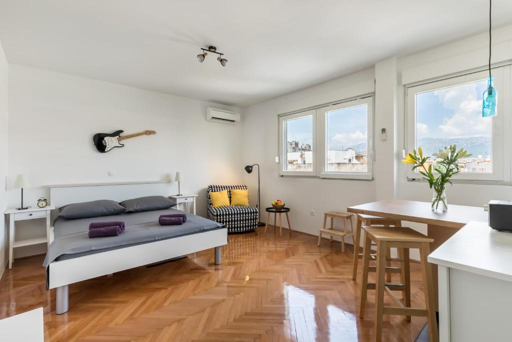 a bedroom with a bed and a kitchen with a table at Aldo apartment in Split