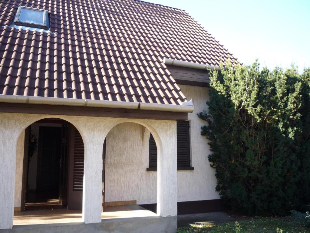 a house with a tiled roof with arches at Iluska Vendégház in Kiskunmajsa