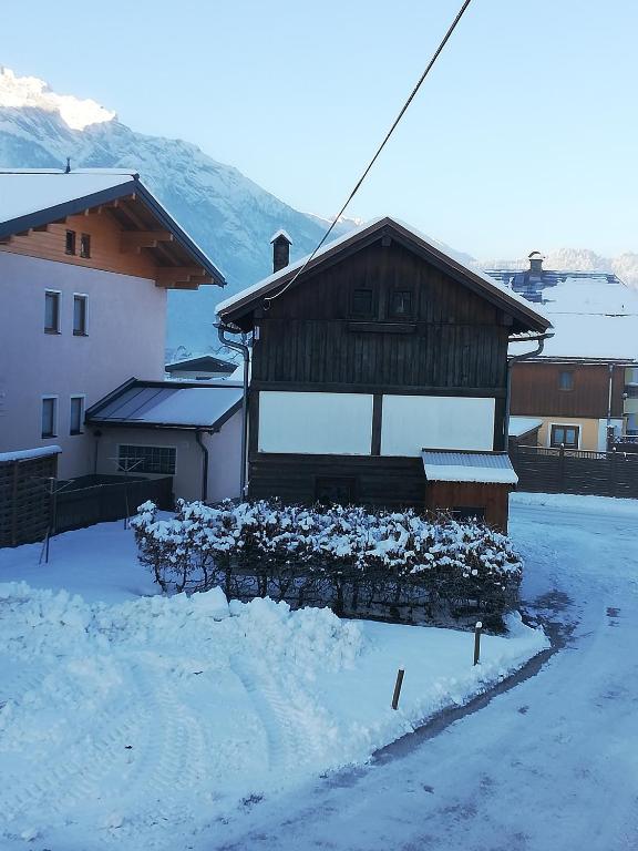 dom ze śniegiem na ziemi przed nim w obiekcie Gaestehaus-Russegger w mieście Abtenau