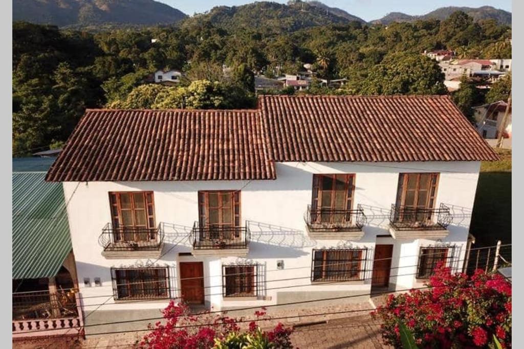 Casa blanca con ventanas y techo en La Casa de Dona Irma Townhouse, en Copan Ruinas