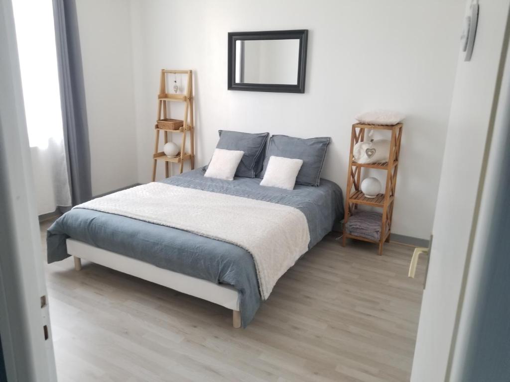 1 dormitorio con 1 cama con sábanas azules y espejo en GITE LE SAINT-AMOUR, en Saint-Amour