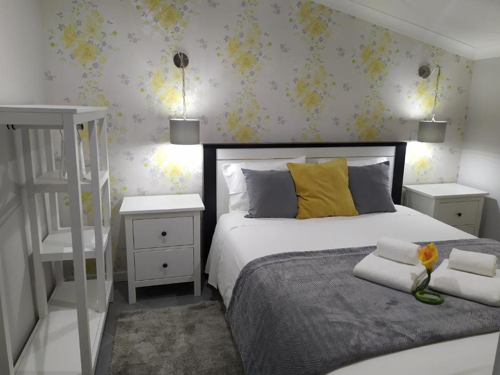 a bedroom with a bed with yellow pillows and two night stands at Casa do Terraço in Nazaré