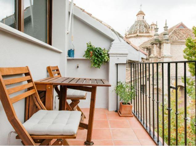 グラナダにあるApartment in the center of Granada, nearby Alhambraの木製テーブルと椅子付きのバルコニー