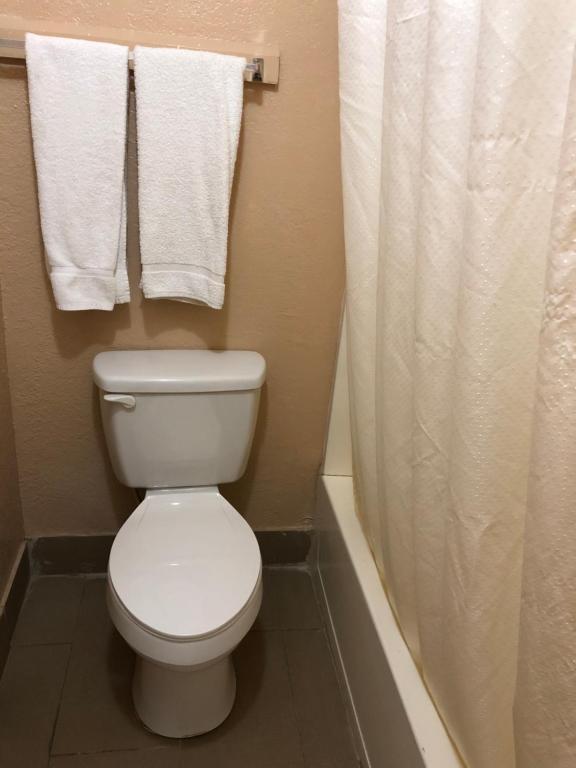 a bathroom with a white toilet and towels at Lone Star Inn in Cisco