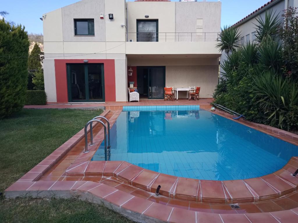 a house with a swimming pool in front of a house at Theo Pool Villa Magnificent Sea View in Kapandrítion