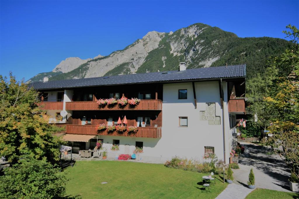 ein Gebäude mit Blumen auf den Balkonen und einem Berg in der Unterkunft Frankenhof in Scharnitz