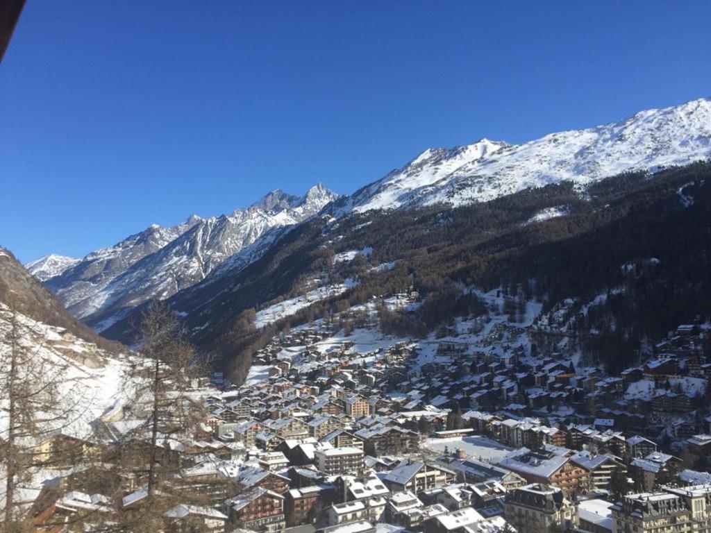 a town in the snow with mountains in the background at Chalet Memory in Zermatt