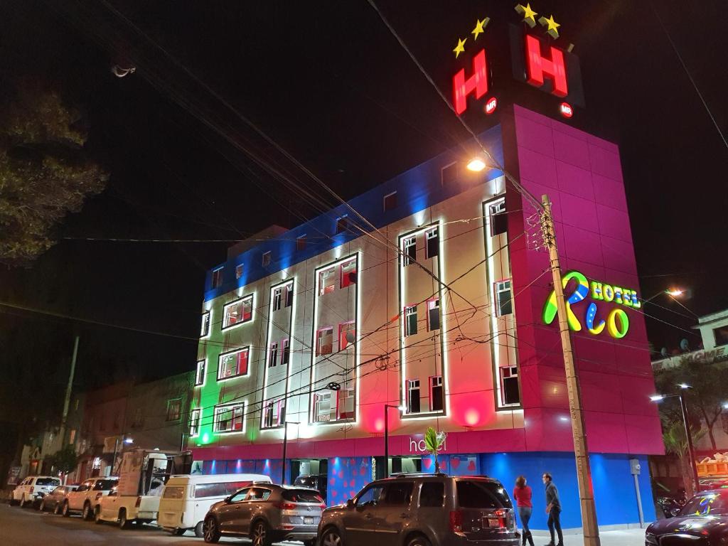 ein Gebäude mit einem Neonschild auf der Seite in der Unterkunft Hotel Río in Mexiko-Stadt
