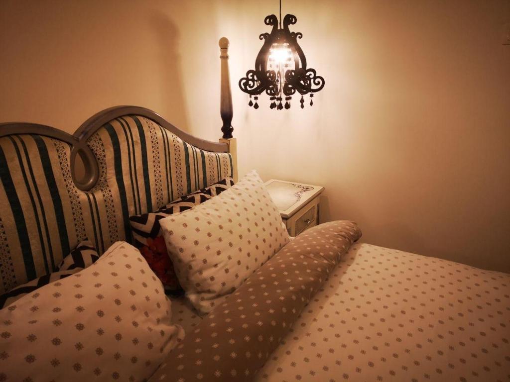 a bedroom with a bed with a chandelier and a pillow at Stay in TimisoarAcom in Timişoara