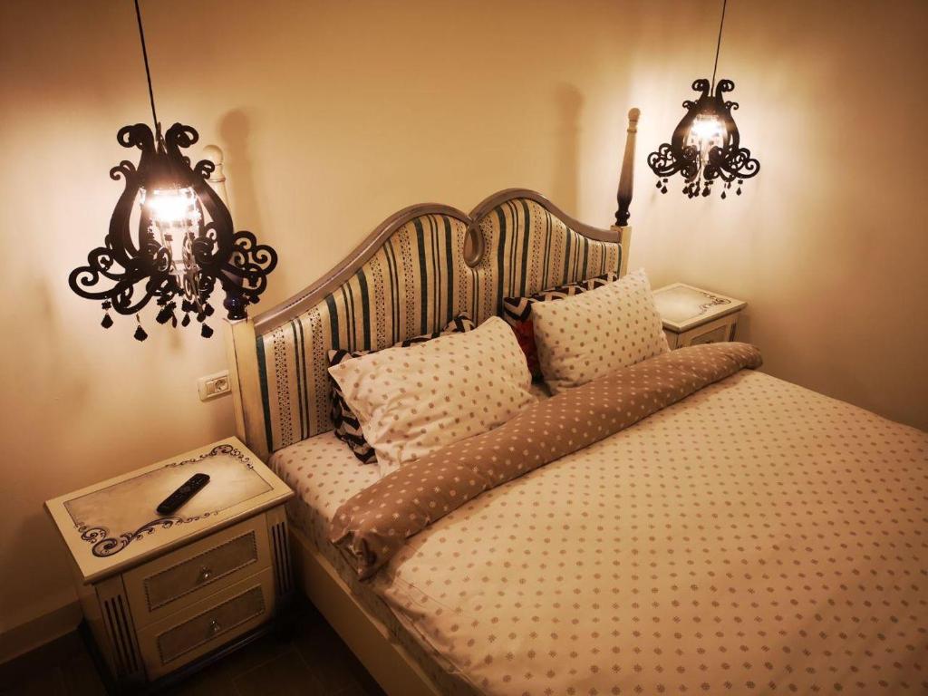 1 dormitorio con 1 cama con 2 luces y 2 mesitas de noche en Stay in TimisoarAcom, en Timisoara