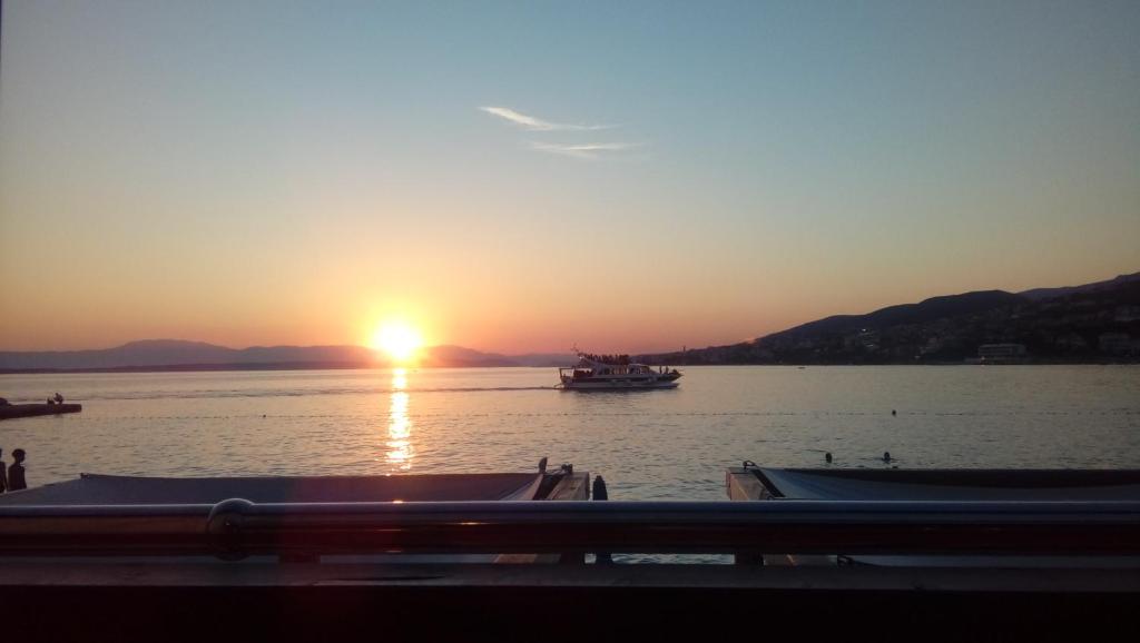 una puesta de sol en el agua con barcos en el agua en CHIARA, en Crikvenica