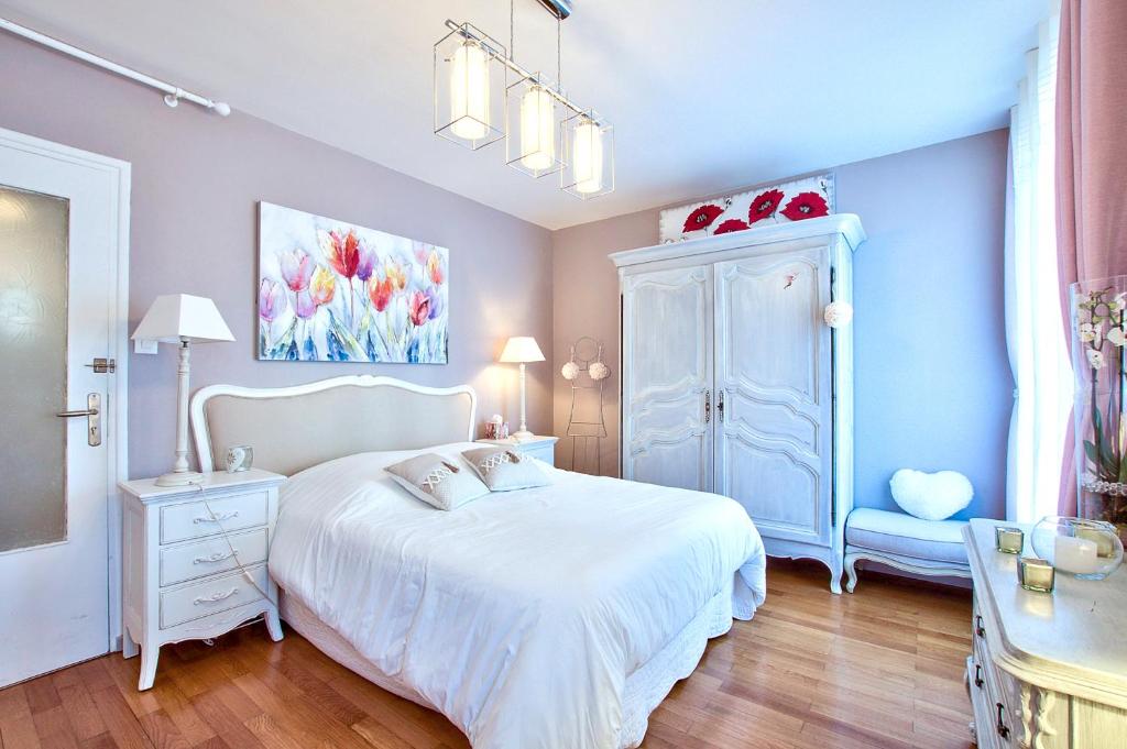 a bedroom with a white bed and a blue cabinet at NATURALBNB - Chambres d'hôtes au calme avec clim - Parking gratuit et sécurisé - Garage vélos et motos - Super petit déjeuner fait maison ! in Villeurbanne