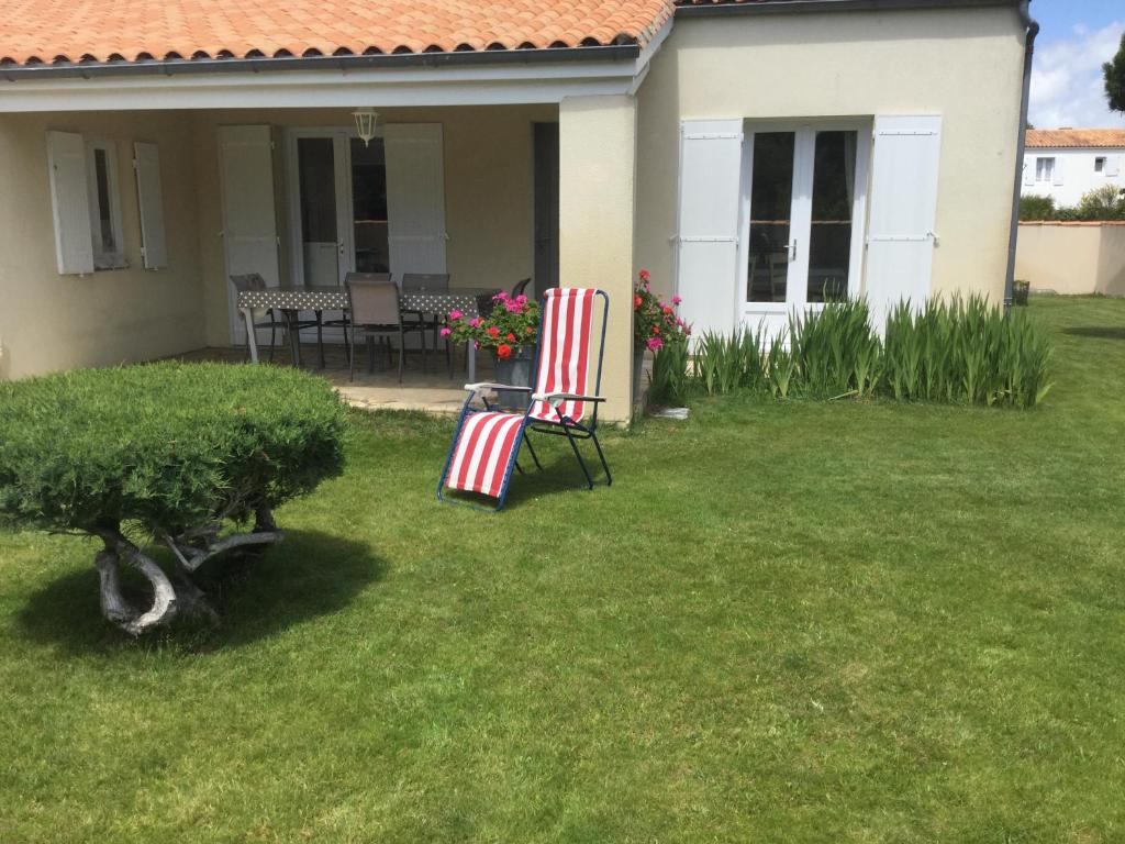 duas cadeiras sentadas no quintal de uma casa em Maison bercée par le bruit de la mer île de ré em Sainte-Marie-de-Ré