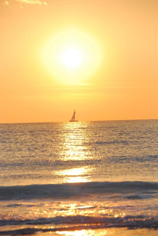 a sail boat in the ocean at sunset at Hotel Signorini in Castiglioncello