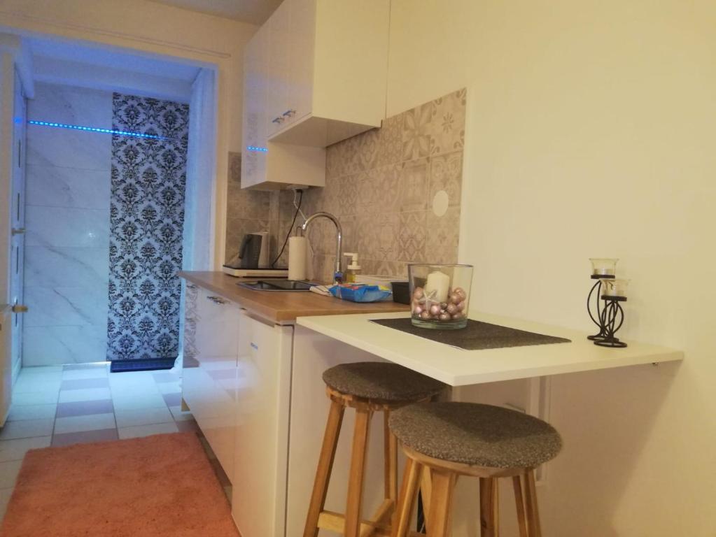 a kitchen with a counter and two bar stools at Studio Apartment New Home in Zagreb