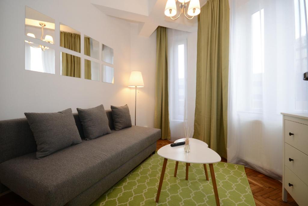 ein Wohnzimmer mit einem Sofa und einem Tisch in der Unterkunft Stay Inn Apartments in Bukarest