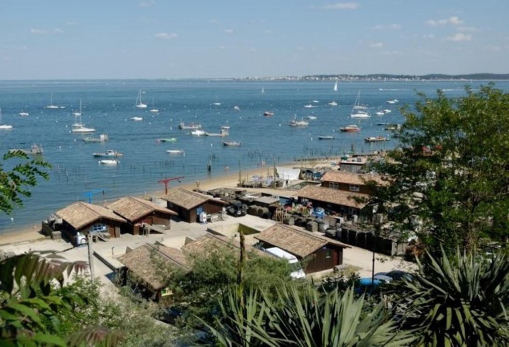 a view of a beach with boats in the water at Appartement cosy village de L'Herbe in Lège-Cap-Ferret