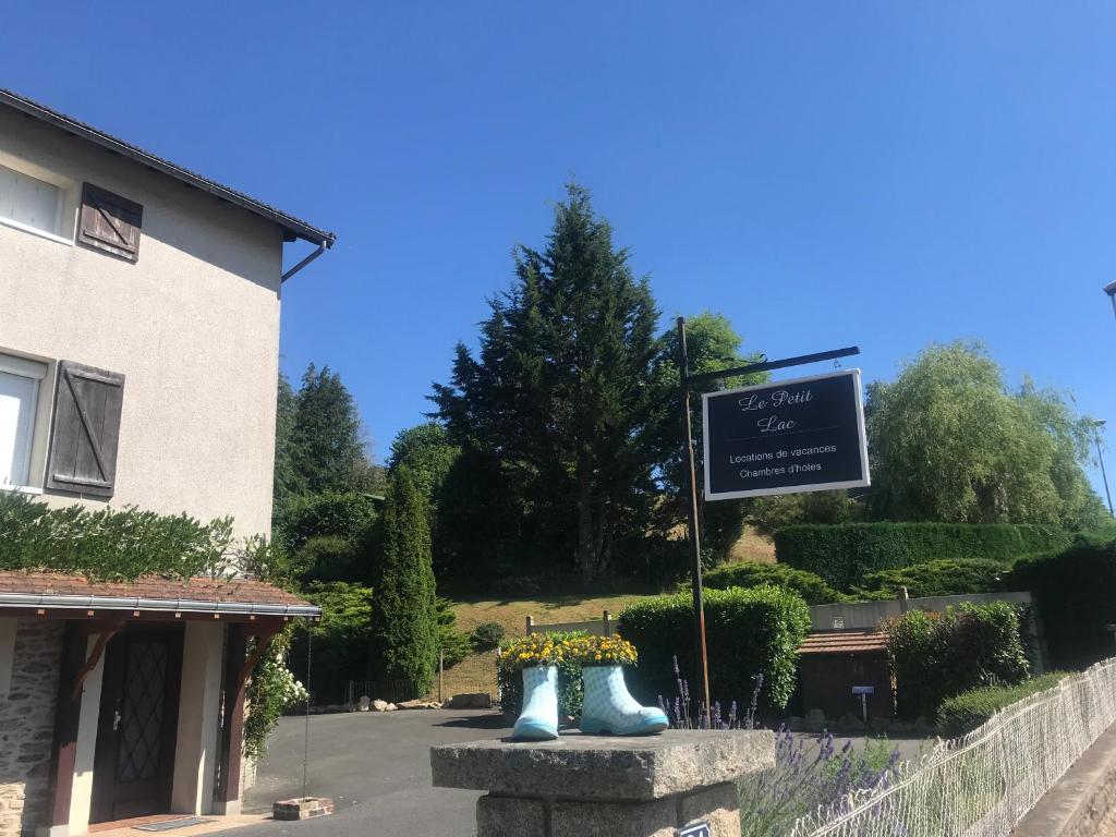 una señal frente a un edificio con botas azules en Le Petit Lac en Bourganeuf