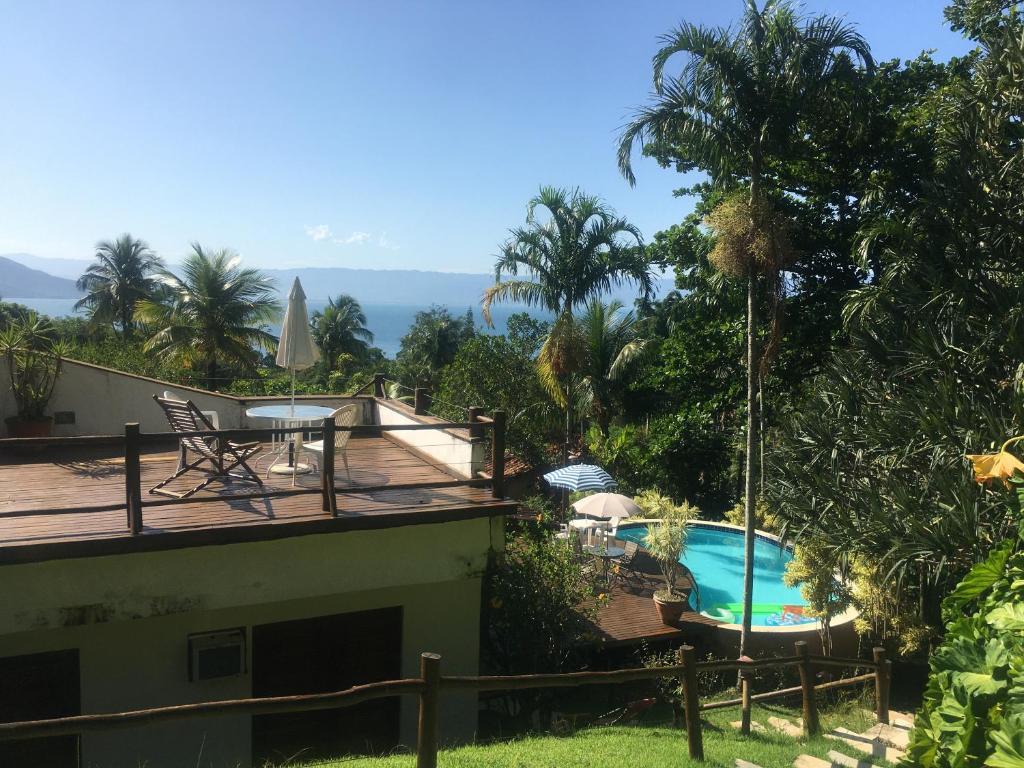 a house with a deck and a swimming pool at Picollo Bambino Suítes Ilhabela in Ilhabela
