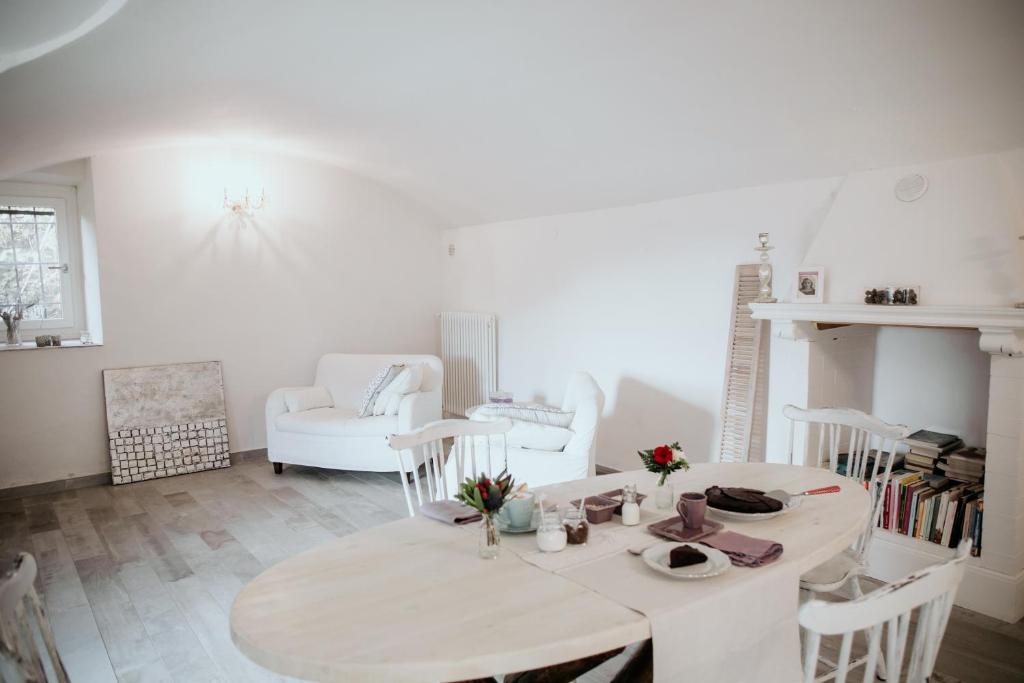 biała jadalnia ze stołem i krzesłami w obiekcie Guest House Al Devesio w mieście Rifreddo
