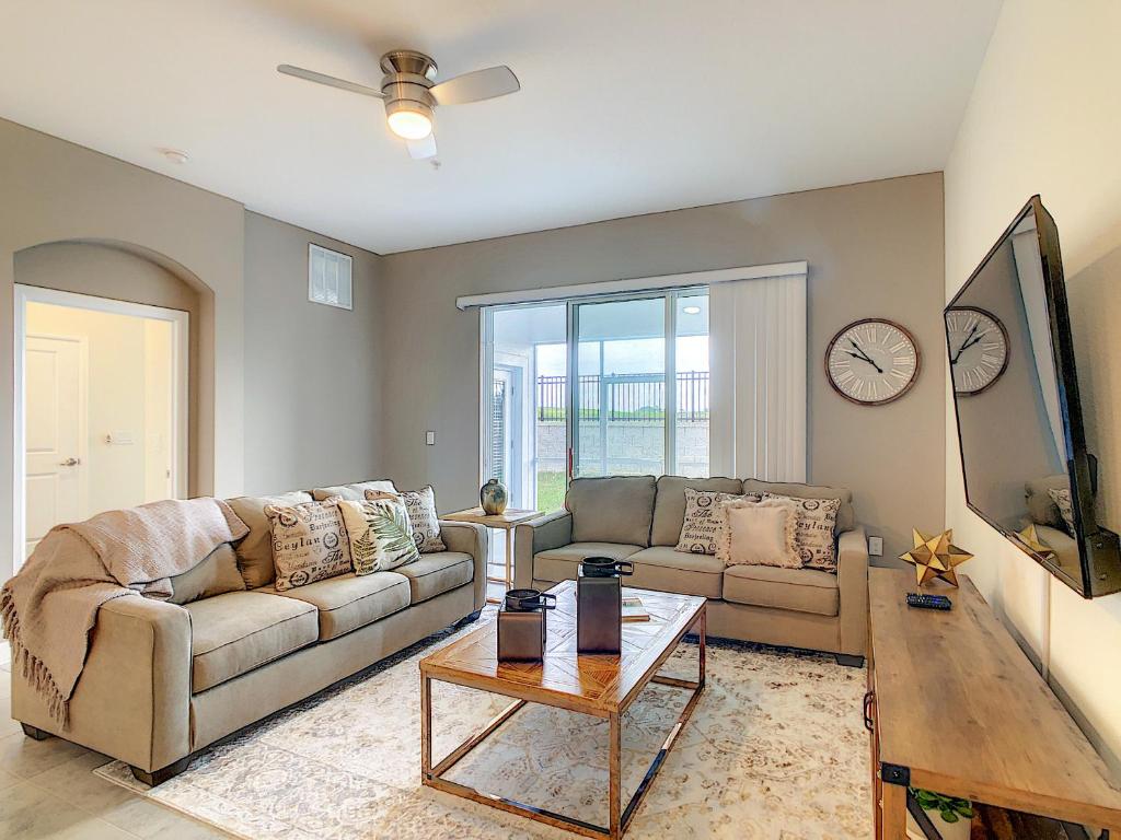a living room with two couches and a table at Gorgeous 2BR with Waterpark & 2 Clubhouses in Kissimmee