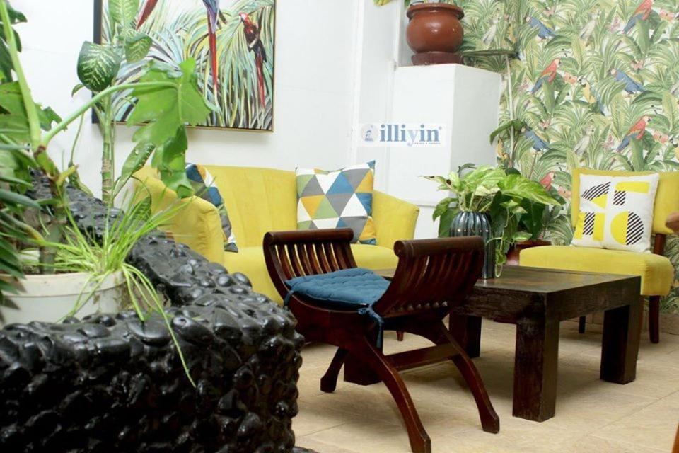 a living room with a couch and a table and chairs at ILLIYIN Boutique Hotel in Dakar