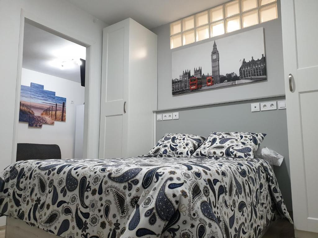 1 dormitorio con 1 cama y 2 cuadros en la pared en Bonito piso Metro Barrio del Pilar, Plaza Padrón en Madrid