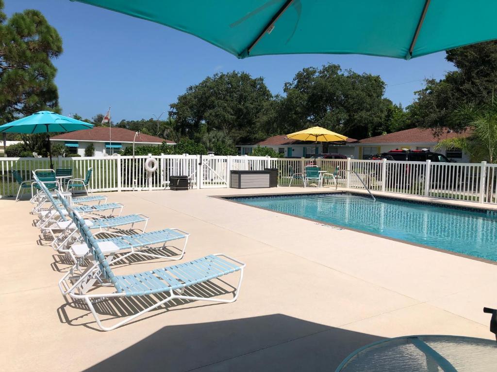 a row of lounge chairs next to a swimming pool at Addy's Villas in Venice