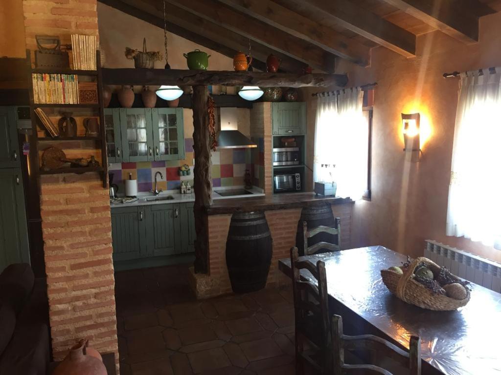 a kitchen with a table and a dining room at Casa Rural La Charolesa in Aguilera